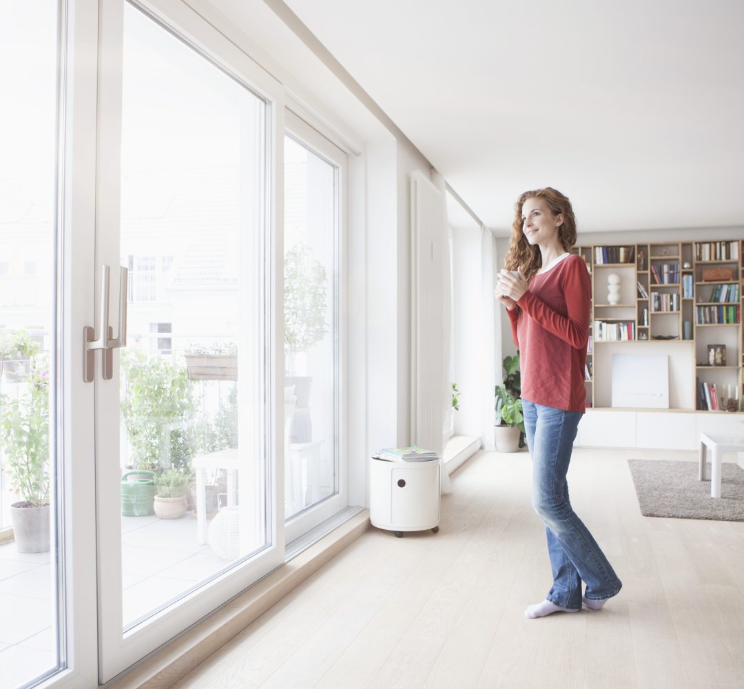 Woman at home looking out of window